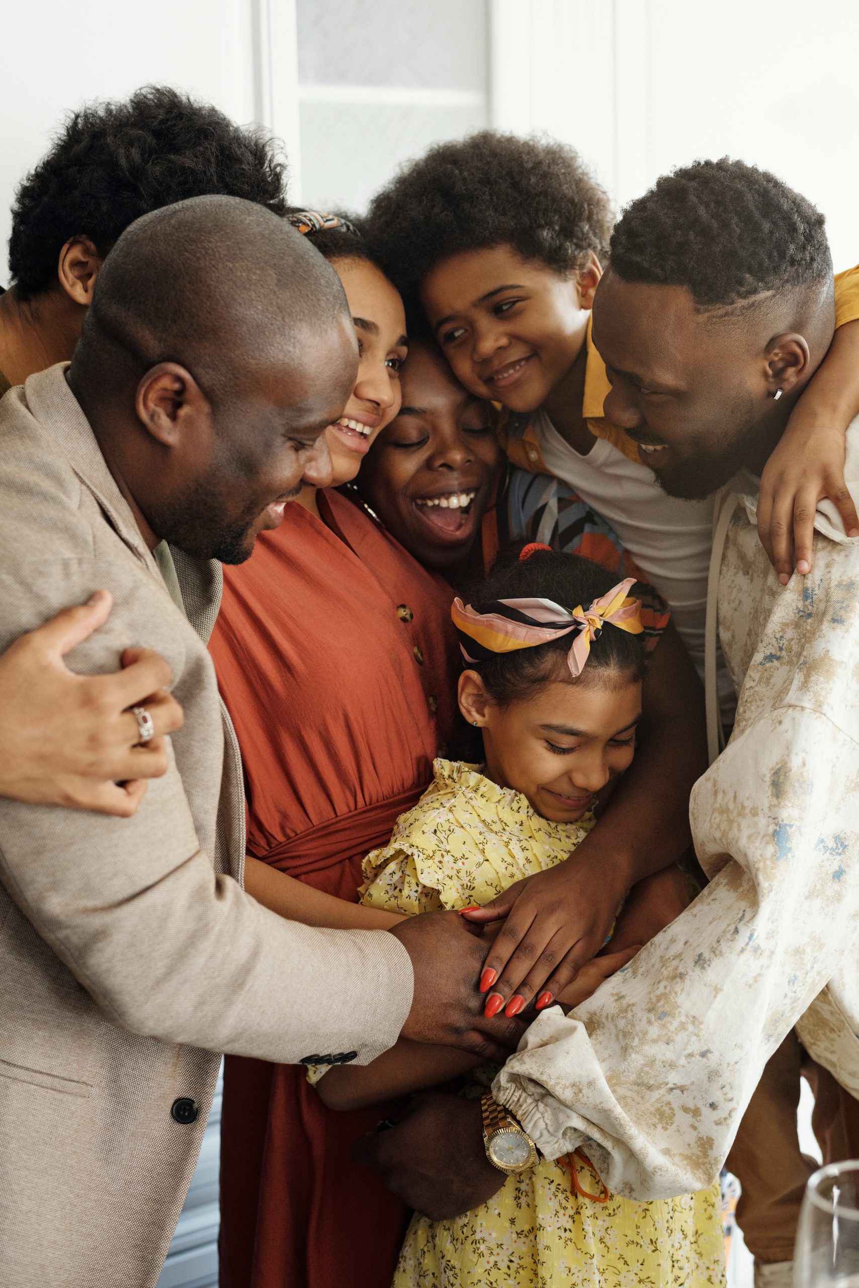 a large happy family hugging each other with young daughter in the middle